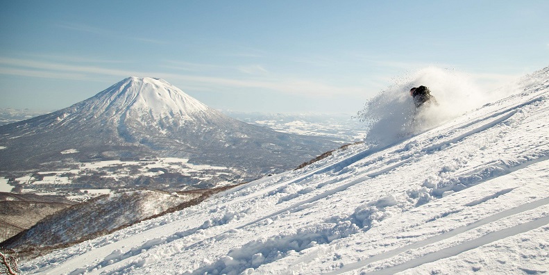 snowboarder in niseko with view of mt. yotei
