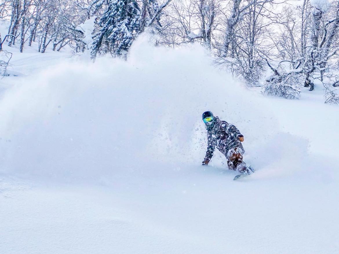 Snowboarder experiencing powder snow in Niseko